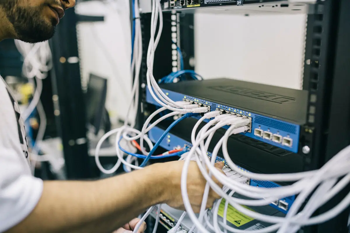Monteur sluit netwerkkabels aan op een switch
